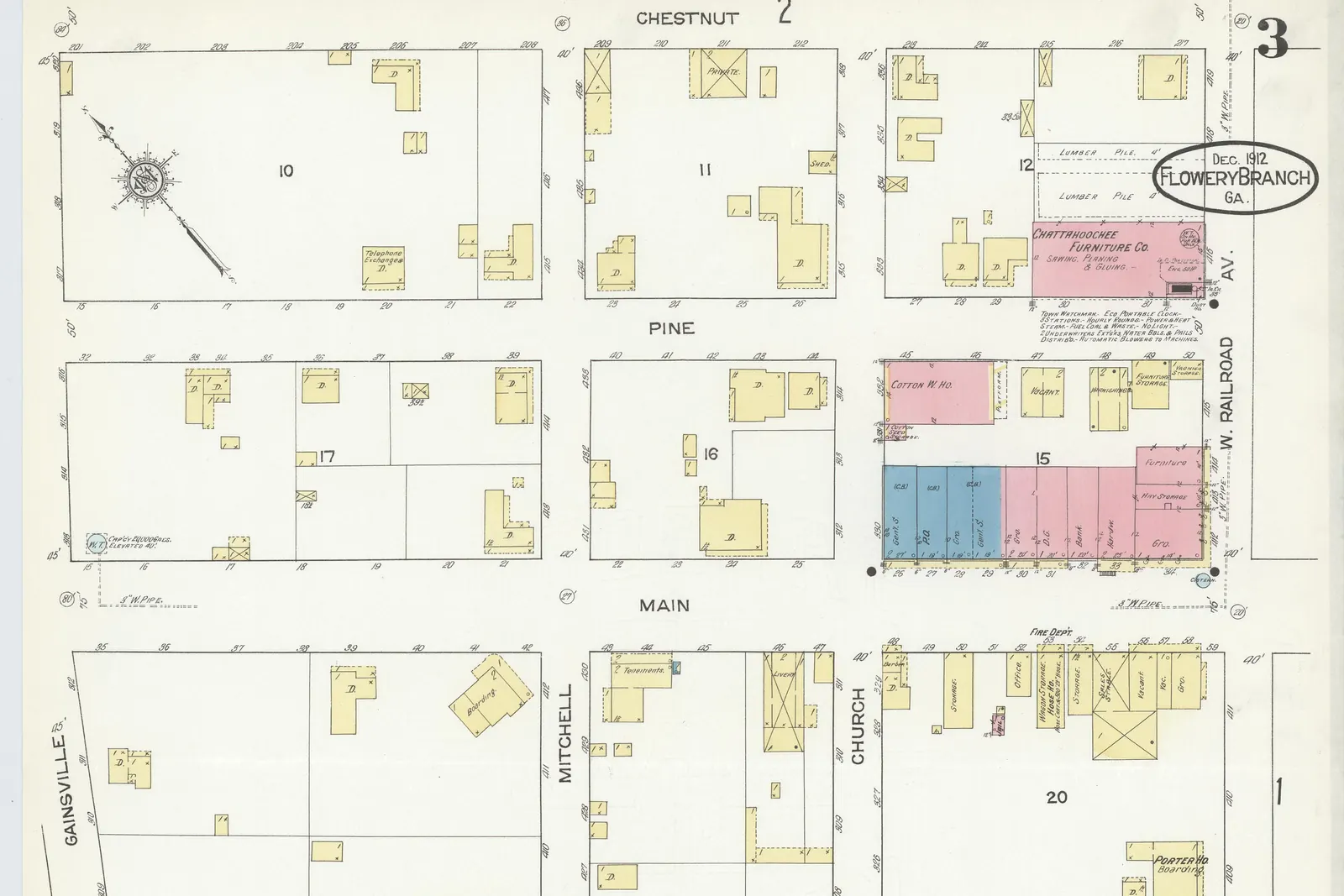 A 1912 fire-insurance map sheet marked 'Dec. 1912 Flowery Branch Ga.' showing a grid of blocks bounded by Chestnut, Pine, Main, Martin, Mitchell, Church, Gainesville and W. Railroad Av.; a row of pink and blue commercial buildings lines a block near Main and W. Railroad Av., a pink building is labelled Chattahoochee Furniture Co., and yellow footprints of smaller buildings fill the other blocks.